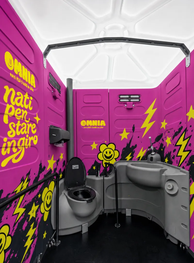 Interno di un bagno chimico Omnia personalizzato con grafiche fucsia e gialle